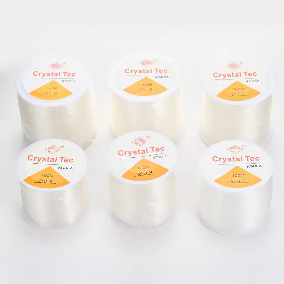 Several spools of Crystal Tec transparent elastic cord for jewelry making and beading are displayed.