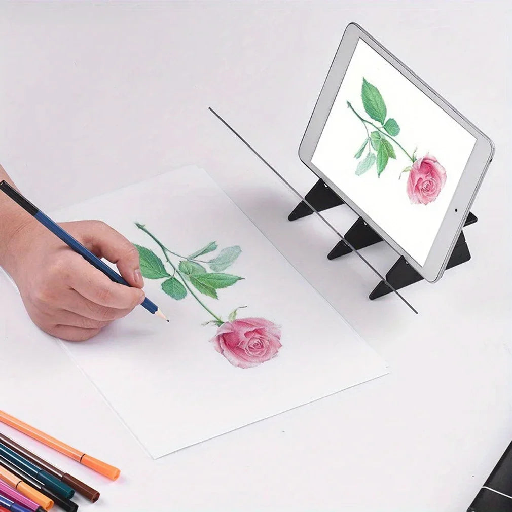 A hand draws a pink rose and leaves on paper next to an iPad displaying the same drawing.