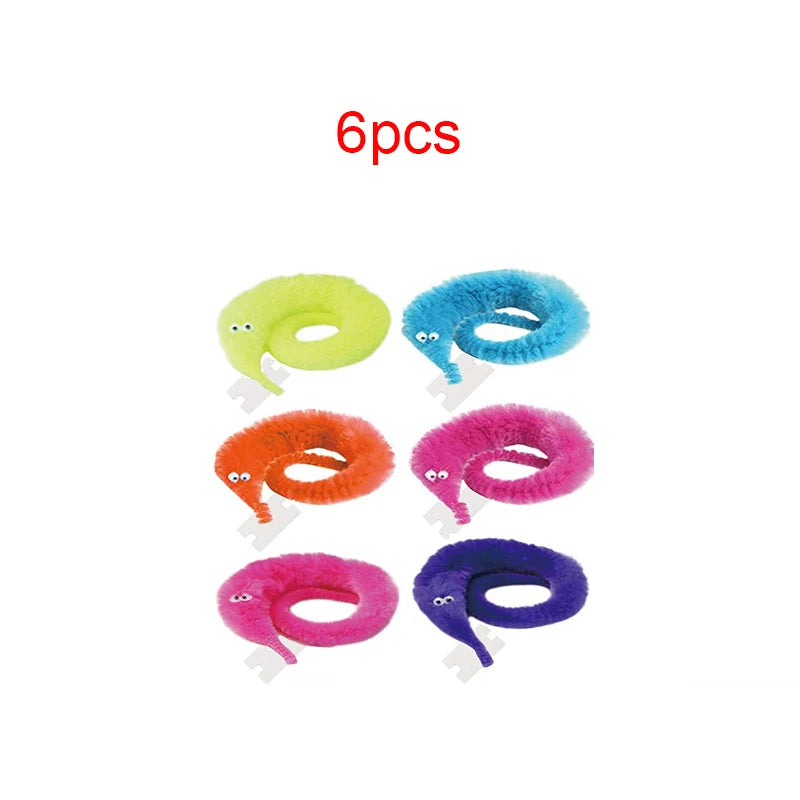 Six fuzzy wiggly worm magic trick props in various colors including yellow, blue, orange, pink, and purple.