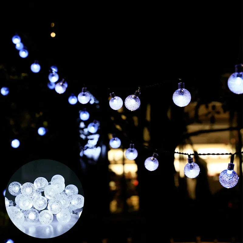 String lights featuring glowing crystal globe bulbs suspended in the dark.