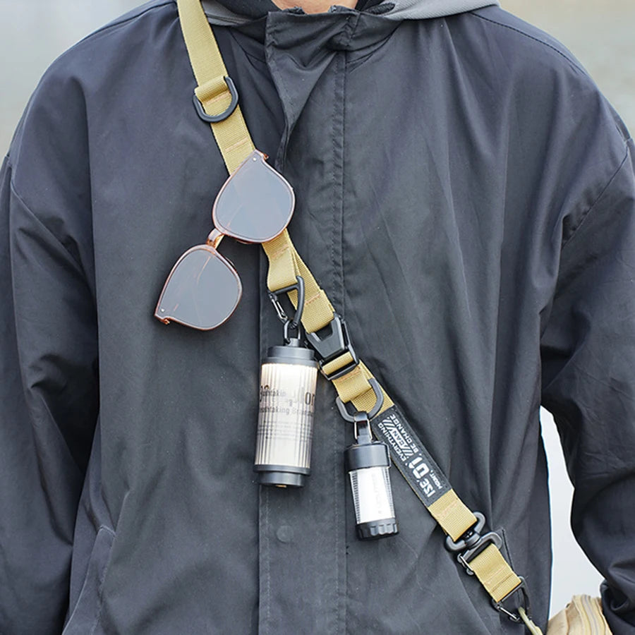 A close-up of a tan strap with hanging rings attached to a dark jacket.
