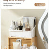 A white expandable vanity cosmetic organizer holding various skincare products on a wooden desk.