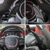 Close-up view of a steering wheel with red anodized aluminum shift paddle extenders and controls.
