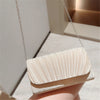 A light beige patent leather clutch bag with vertical pleats and a silver chain strap.
