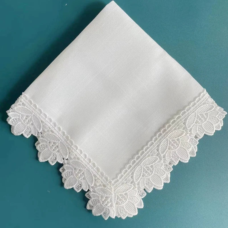 White linen hemstitch napkins with delicate white lace trim displayed on a teal background.