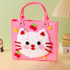 Pink felt cat tote bag with red accents and a pink fabric background.