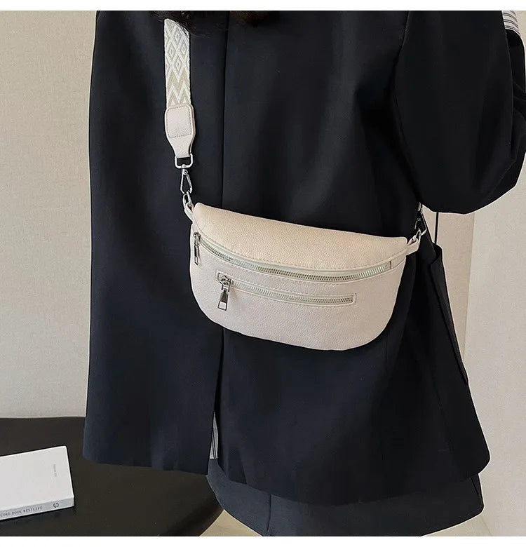 A black blazer features a cream-colored multi-pocket PU leather waist bag with an adjustable strap attached to the shoulder.
