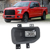 A close-up view of a black fog light assembly with a clear lens and halogen bulbs for a Ford F-150.