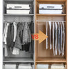 A storage cabinet displaying hanging winter clothing, compression bags, and folded textiles.