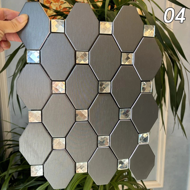 A collection of gray hexagonal mosaic tiles arranged in a geometric pattern, held by a hand against a green plant background.