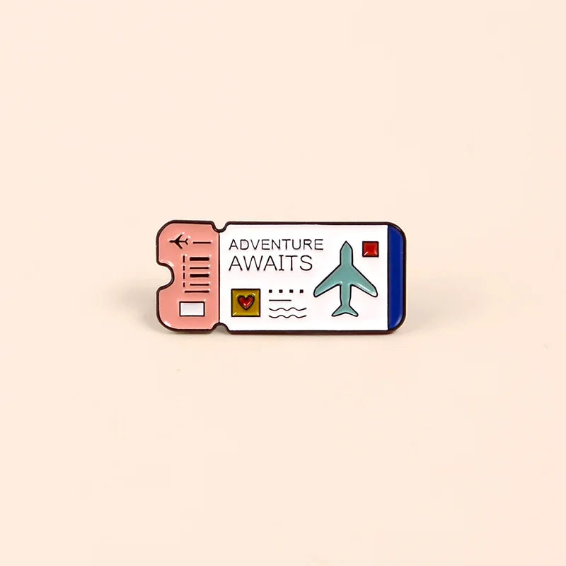 A vintage airline ticket enamel brooch featuring an adventure awaits design with a plane and heart symbols.