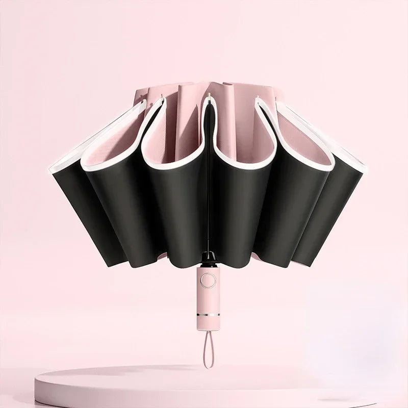 A pink fully automatic reverse-folding windproof umbrella with UV protection displayed against a light pink background.