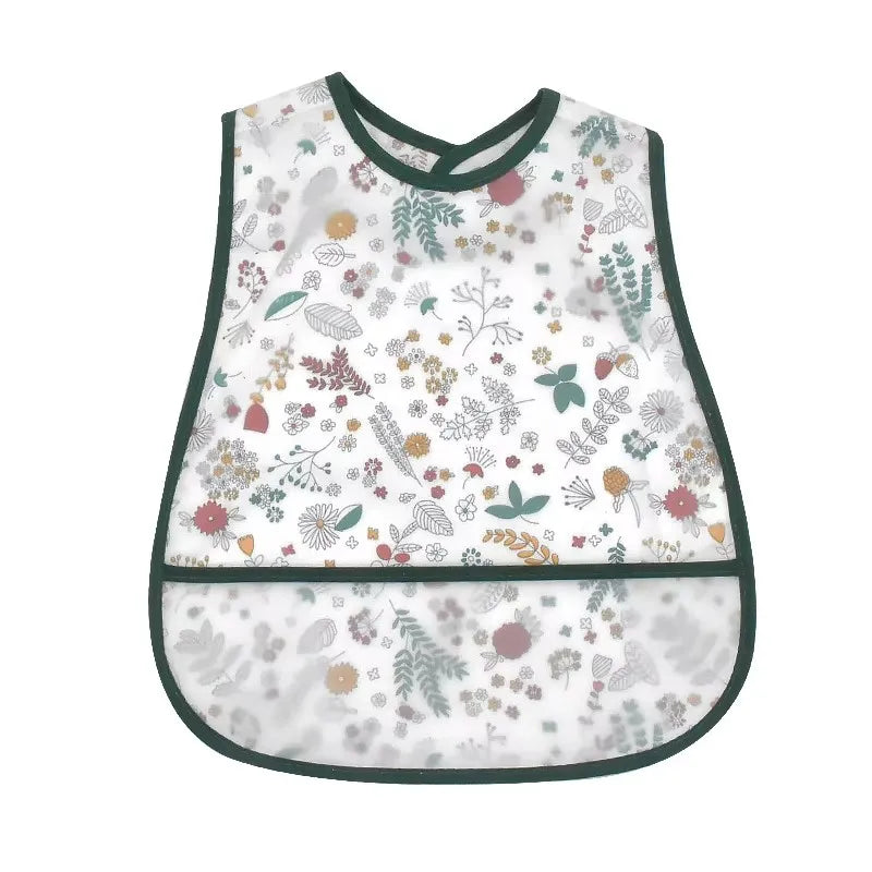 A white baby feeding bib with a green trim featuring a floral pattern and a catch pocket.