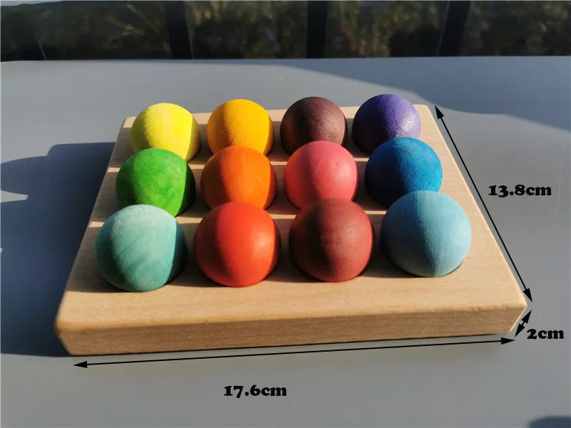 Holztablett mit zehn farbenen, kugelförmigen Blüten in Regenbogenanordnung für ein Musikspielzeug.