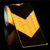 Roll of high-visibility reflective safety tape showing a yellow chevron pattern against a black background.