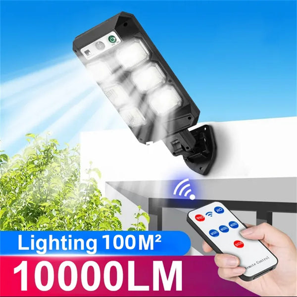 A black solar-powered LED security light with a motion sensor shining a bright beam onto a white wall.