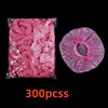 A package of pink disposable shower caps for hair protection and salon use.
