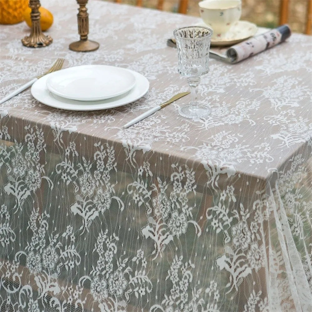 Elegant white lace tablecloth with French retro floral design set for a wedding or party.