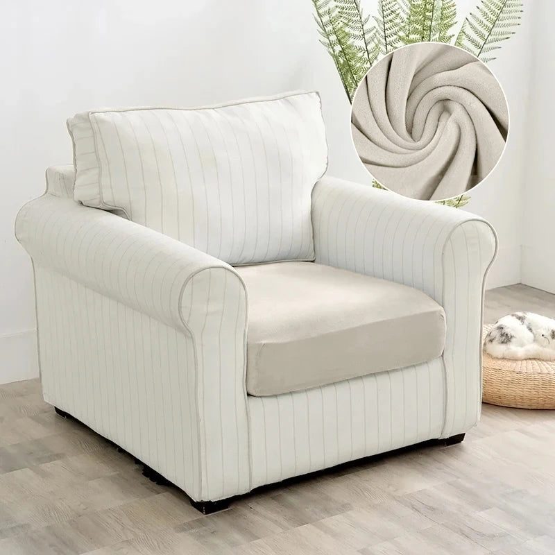 A cream-colored plush velvet stretch sofa seat cover with vertical stripes shown in a living room setting.