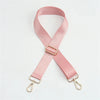 Pink nylon bag strap with a gold buckle shown diagonally.