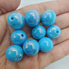A handful of bright blue iridescent acrylic beads for jewelry making
