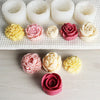 A collection of pink and yellow 3D rose peony silicone molds for crafts displayed on a white surface.