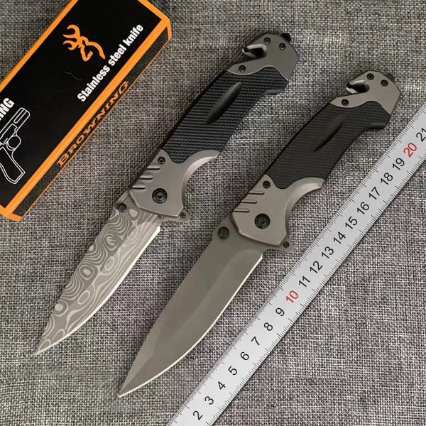 A stainless steel folding pocket knife with a silver blade and black handle is shown next to a ruler.