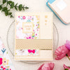 A square piece of light yellow postage stamp paper with pink floral designs and a decorative border.
