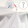 Elegant lace canopy mosquito net hanging from a ceiling hook for a bed