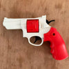 A white and red mini mechanical revolver water gun is shown on a wooden surface.