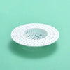 A white universal silicone sink drain filter strainer with a perforated design against a light green background.