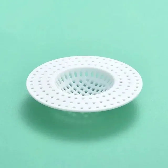 A white universal silicone sink drain filter strainer with a perforated design against a light green background.