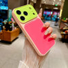 A hand holds a pink phone case with a lime green camera window and a bright pink back panel.