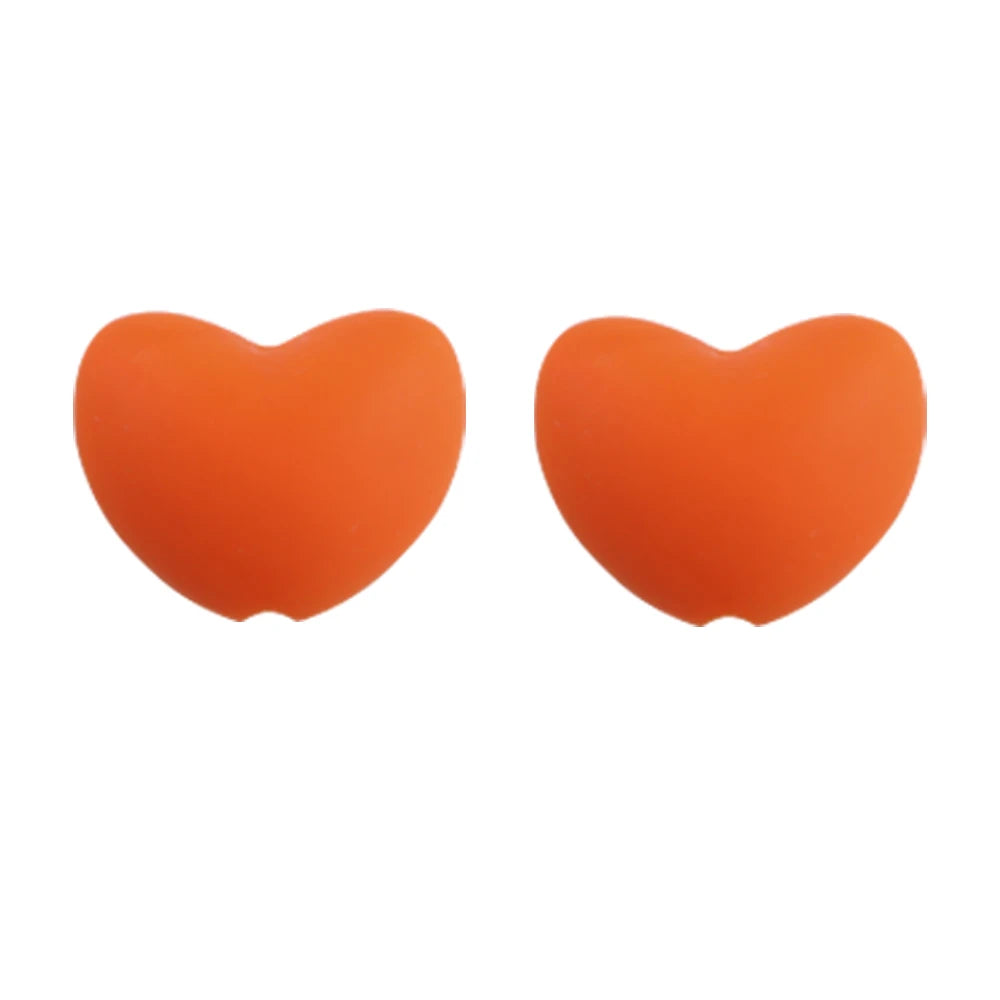 A pair of bright orange silicone heart beads for DIY jewelry making