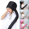 A woman wearing a black reusable hair drying and conditioning cap, demonstrating its use.