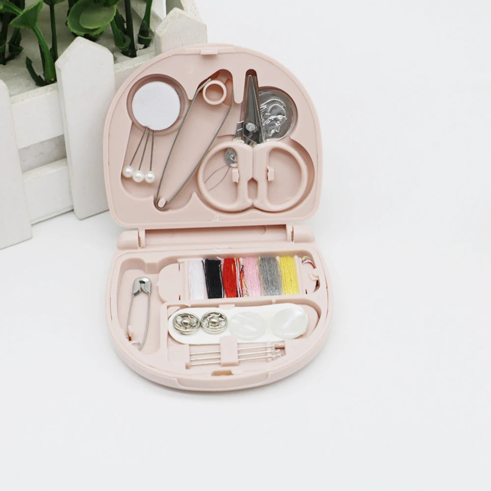 A pink portable mini sewing kit with various needles, scissors, and tools is displayed in an open case.
