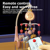 A hand holds a remote control for a baby crib mobile with a projector and night light.