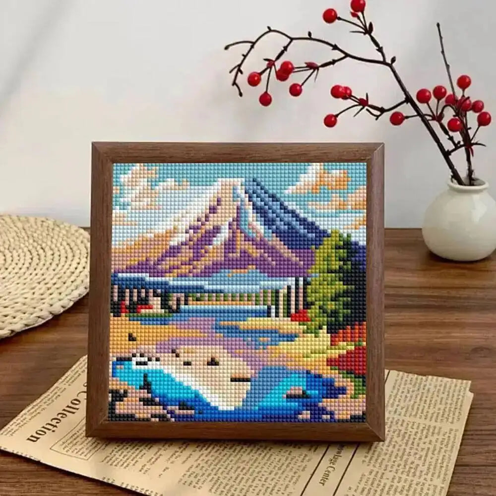 Diamond painting kit featuring a colorful sunset mountain landscape with trees and water.
