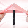 A hand holds up a pink nitrile glove, showing the folded shape and the black packaging.