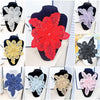 A collection of 12 floral lace applique patches in various colors and textures, including red, purple, black, gold, silver, b