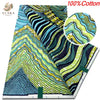 Close-up view of a vibrant green and blue striped cotton fabric with yellow accents
