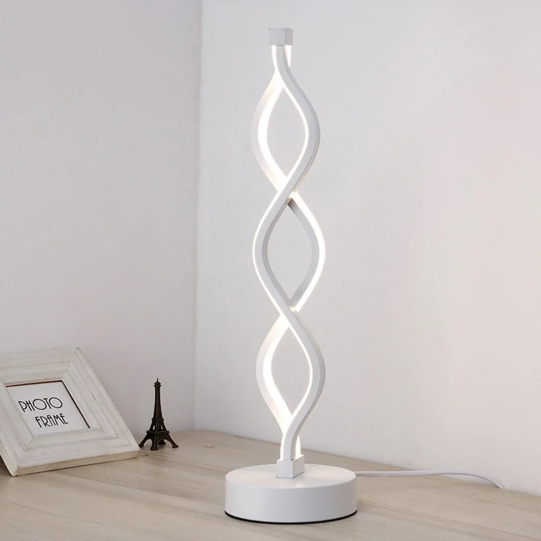A white, USB-powered desk lamp shaped like a swirling seaweed, emitting a soft ambient glow.