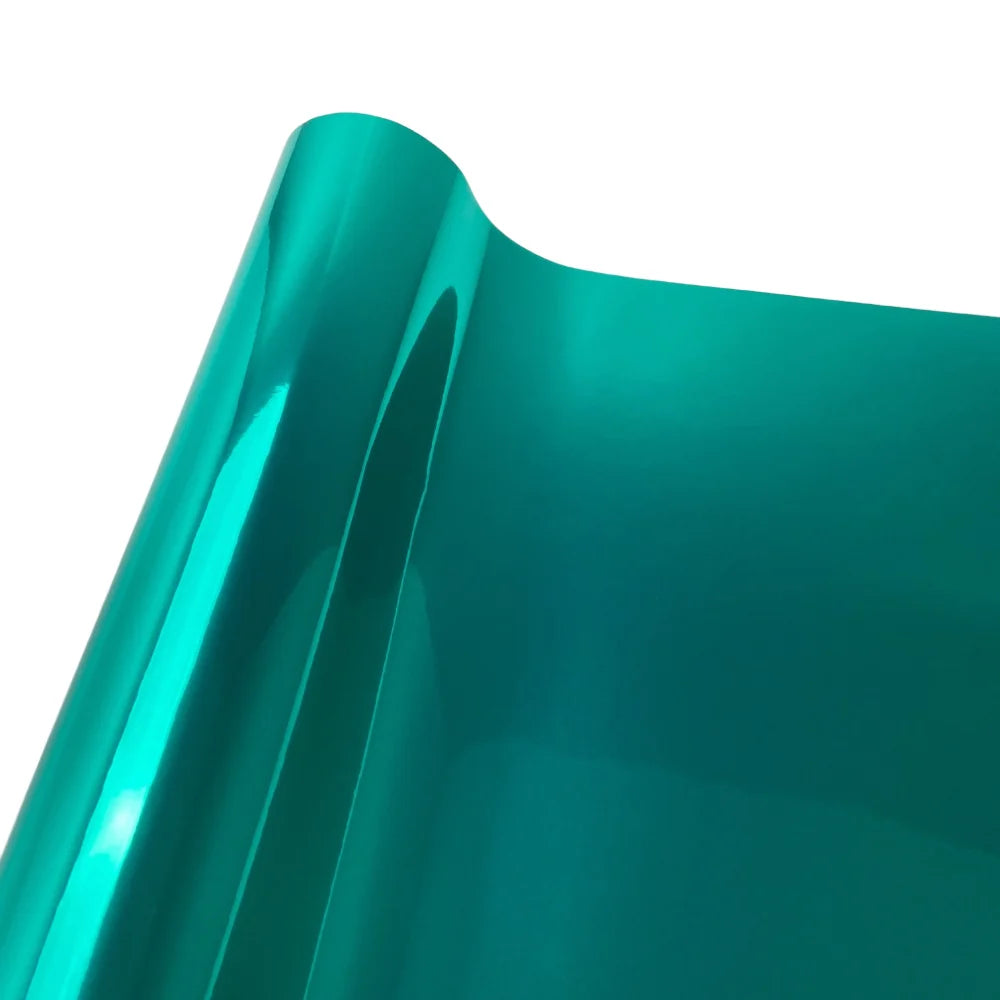 A close-up view of a glossy teal chrome mirror car wrap vinyl film surface.