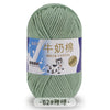 A ball of light green milk cotton blend yarn with a label in Chinese and English.