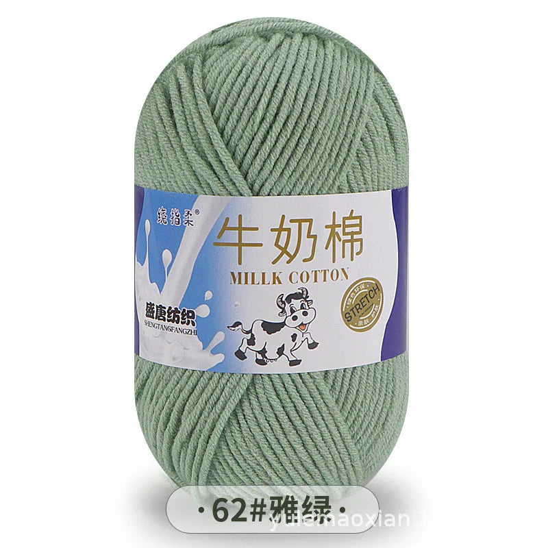A ball of light green milk cotton blend yarn with a label in Chinese and English.
