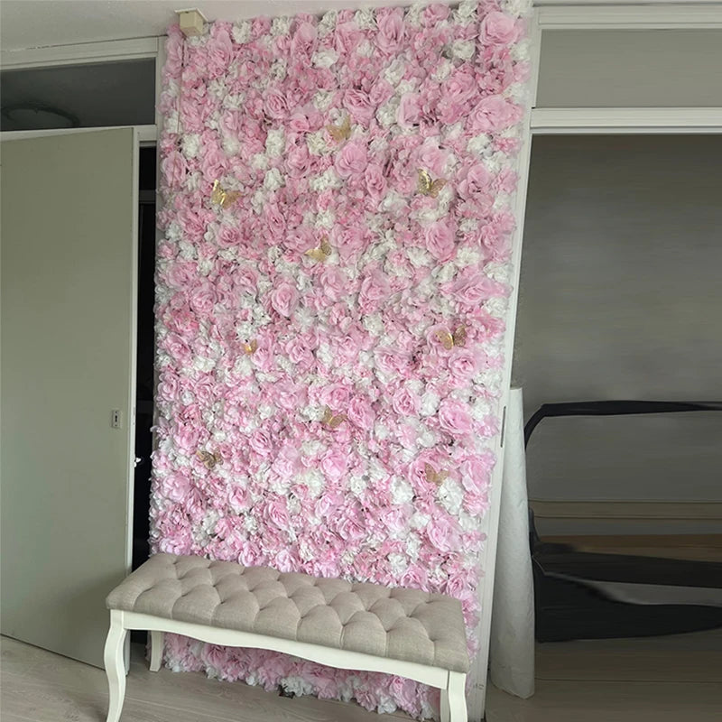 A vertical wall panel covered entirely in pink and white silk rose flowers, displayed next to a bench.