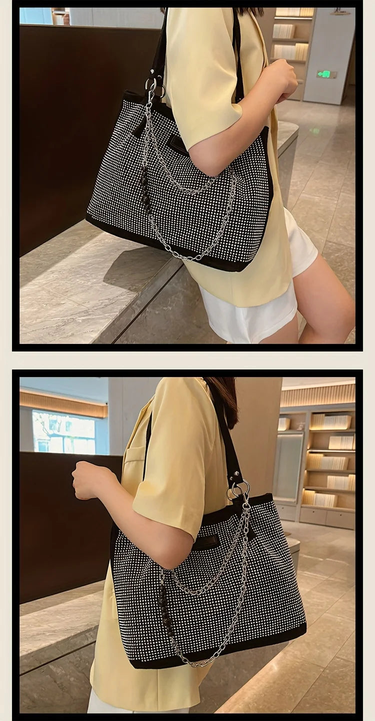 A person holds a black and white crystal-embellished chain shoulder bag with a gold-yellow top.