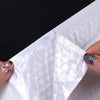 A hand is sealing a white padded bubble mailer with a self-seal closure.