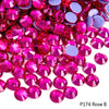 A close-up of pink and purple faceted rhinestones scattered on a white background.