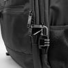 Close-up of a black backpack featuring a zippered pocket with a security lock.